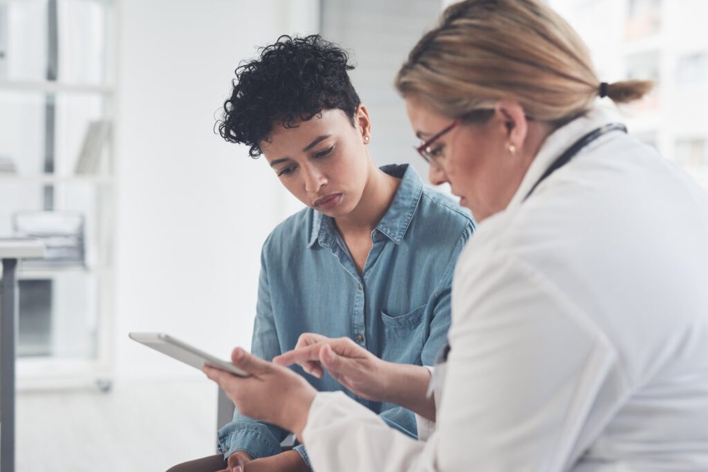 Doctor showing a patient information on a tablet: medical practice website design