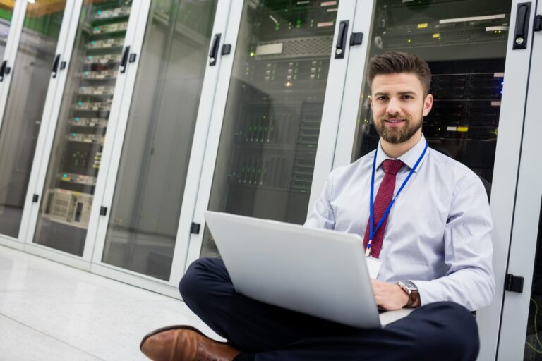 Technician with a laptop in a data center: move your website to a new host